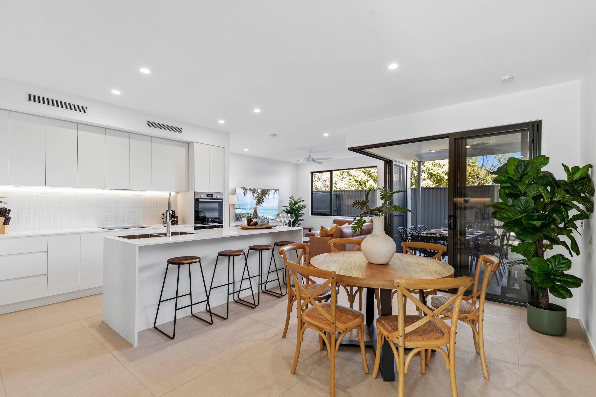 AirBNB — white kitchen with island and timber dining table