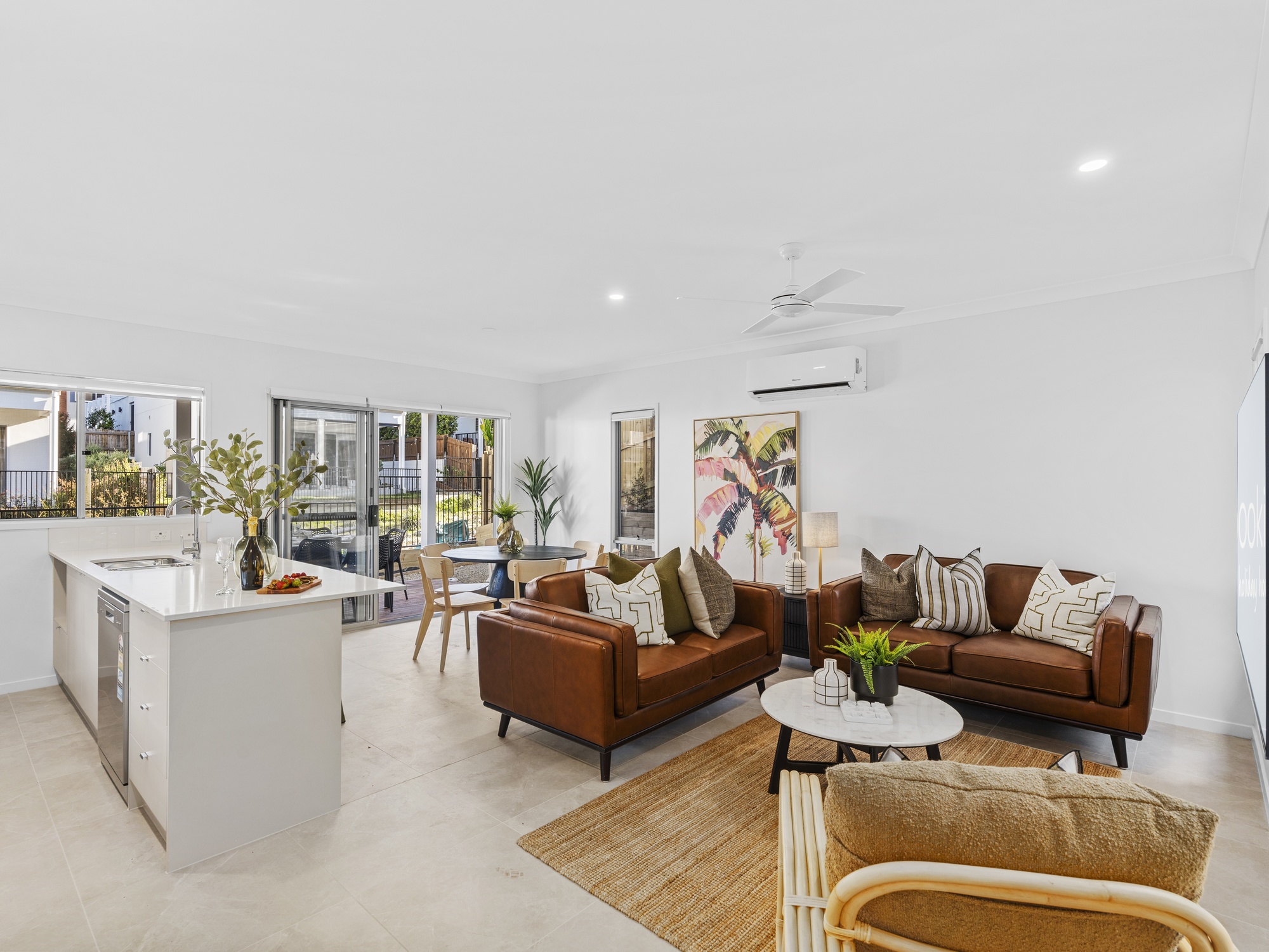AirBNB — open-plan lounge and kitchen with tan leather sofas