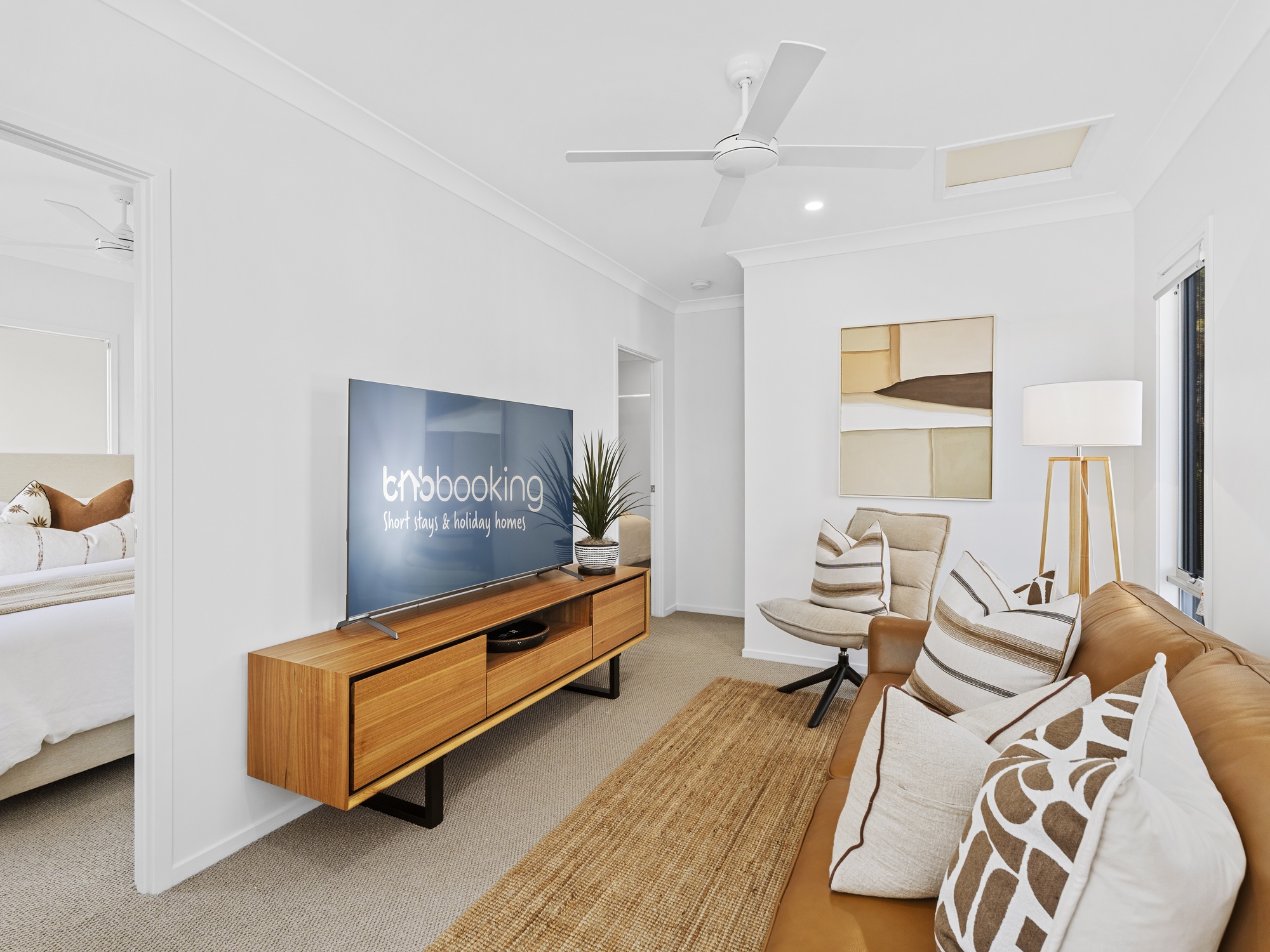 AirBNB — media lounge with tan sofa and timber console